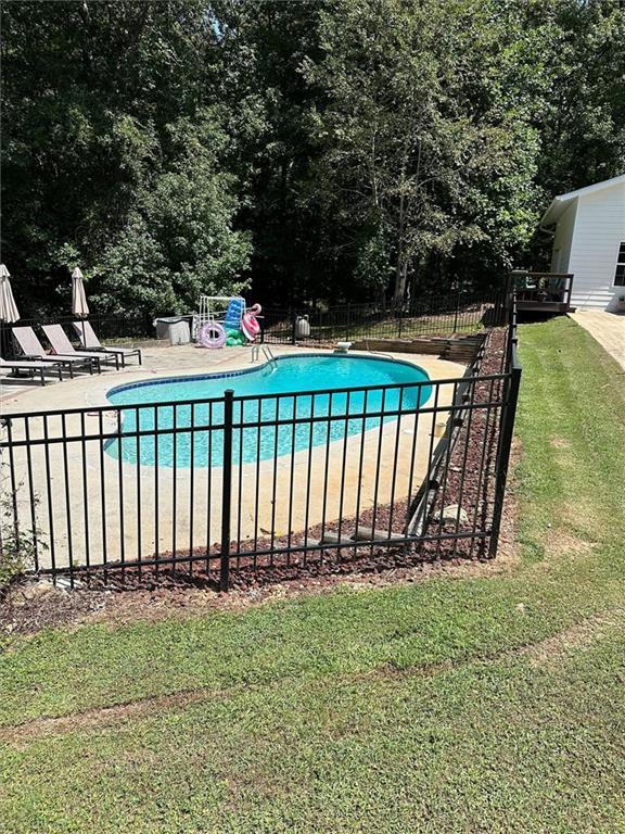 view of pool featuring a lawn, a diving board, and a patio