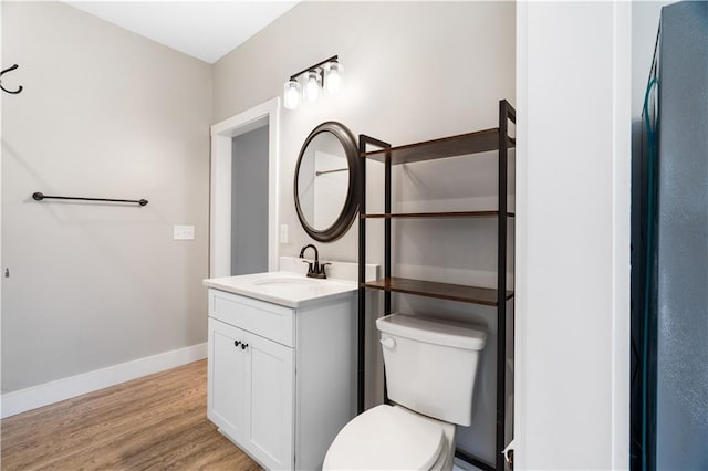 bathroom with hardwood / wood-style floors, vanity, and toilet