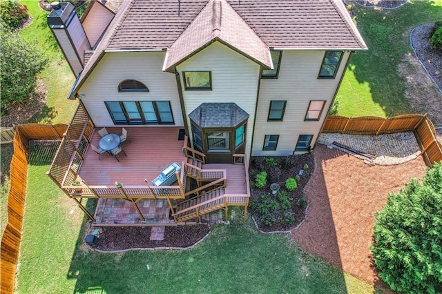 back of house with a deck and a yard