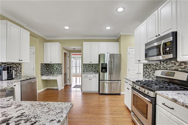 kitchen with white cabinets, appliances with stainless steel finishes, backsplash, light hardwood / wood-style floors, and light stone countertops