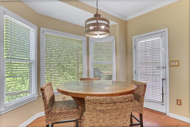 dining area with crown molding, an inviting chandelier, and light hardwood / wood-style floors