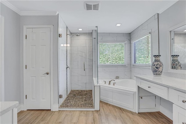 bathroom featuring ornamental molding, independent shower and bath, vanity, and hardwood / wood-style flooring