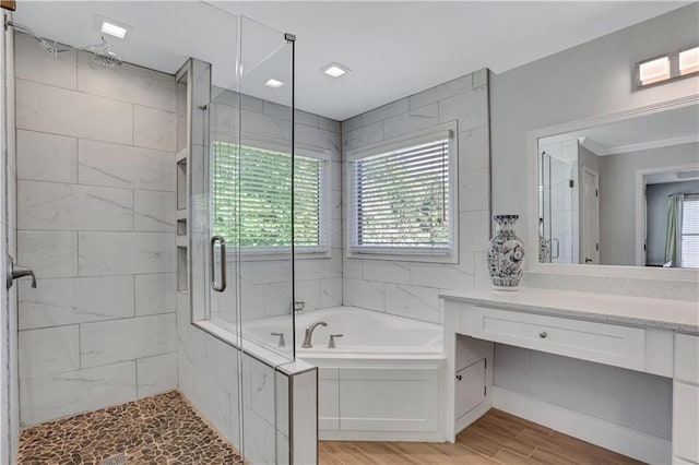 bathroom with shower with separate bathtub, a wealth of natural light, oversized vanity, and wood-type flooring