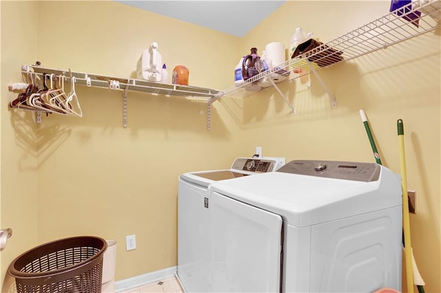 clothes washing area featuring washing machine and clothes dryer and light tile floors