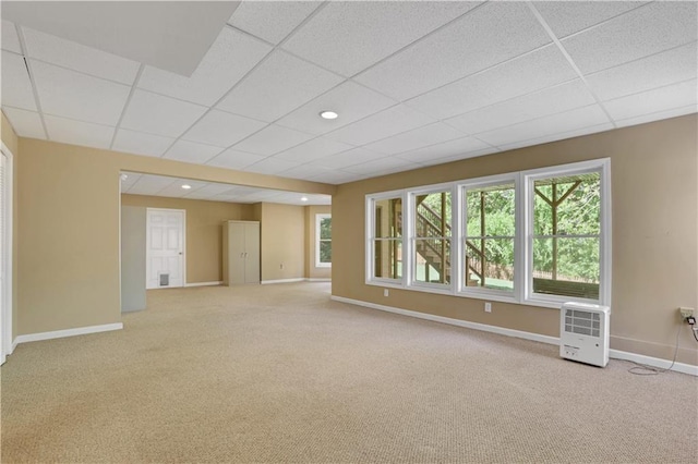 unfurnished room with plenty of natural light, a drop ceiling, and light carpet