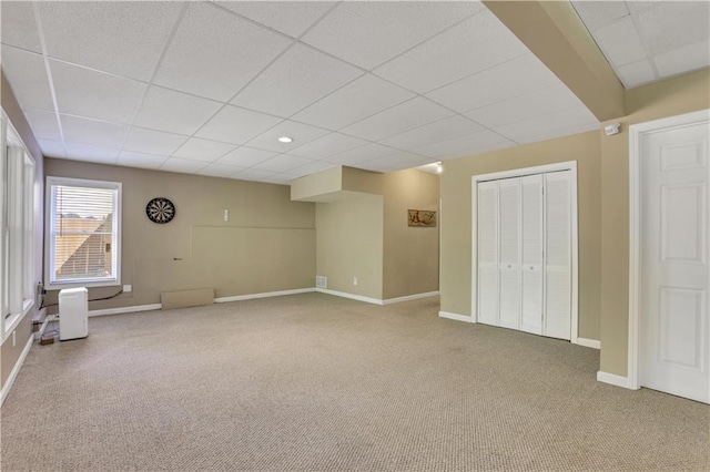 interior space featuring a closet, light carpet, and a drop ceiling