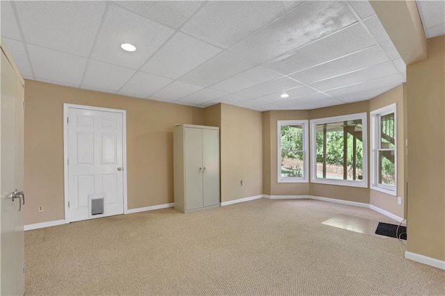 carpeted empty room with a drop ceiling