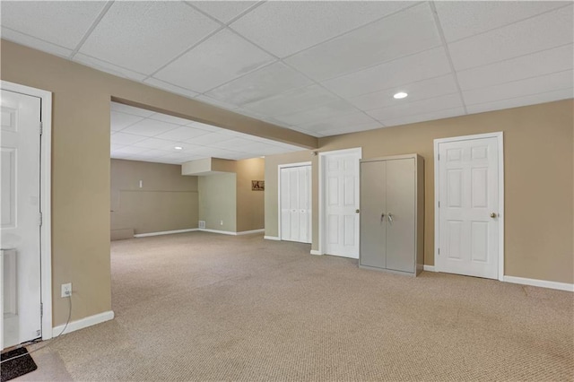 carpeted spare room featuring a drop ceiling