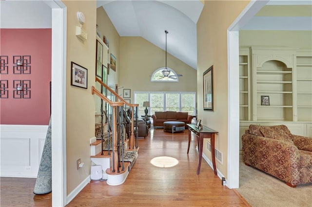 foyer entrance with lofted ceiling and light colored carpet