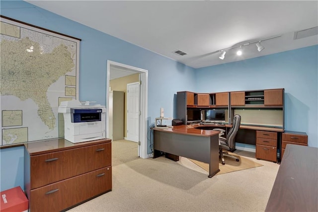 carpeted home office featuring track lighting