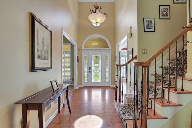 foyer entrance featuring a high ceiling and wood-type flooring