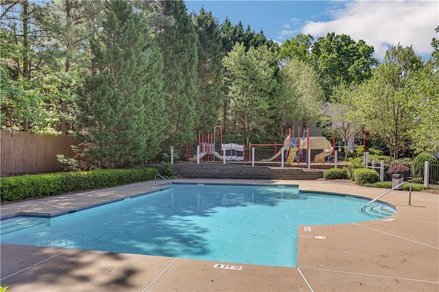 view of swimming pool with a playground