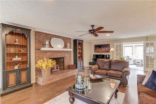 82 Cedar Blf, Winder, GA 30680 - living area featuring ceiling fan, wood finished floors, ornamental molding, a fireplace, and built in features