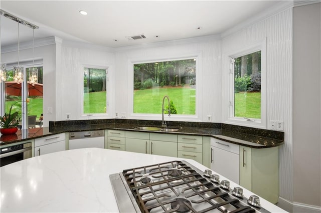 kitchen with visible vents, dark stone countertops, white dishwasher, hanging light fixtures, and a sink