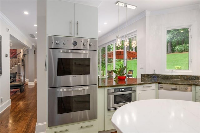 kitchen with dark stone countertops, dark wood-style flooring, ornamental molding, dishwasher, and double oven