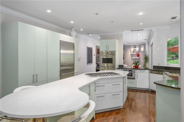 kitchen featuring visible vents, a center island, dark wood-type flooring, ornamental molding, and stainless steel appliances