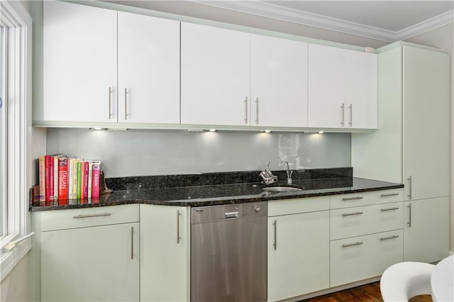 kitchen featuring dark stone countertops, a sink, ornamental molding, white cabinets, and stainless steel dishwasher