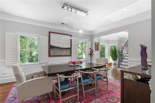 dining area with a wealth of natural light, stairway, a decorative wall, and ornamental molding