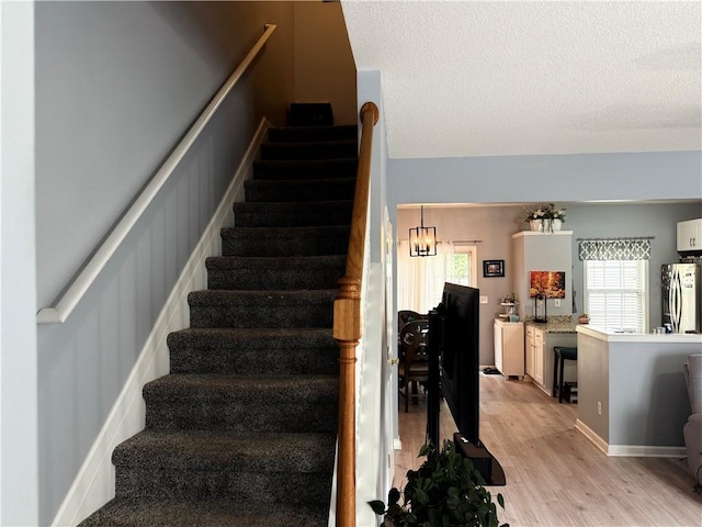 4172 Howell Park Rd, Duluth, GA 30096 - stairway featuring wood finished floors, plenty of natural light, and a textured ceiling