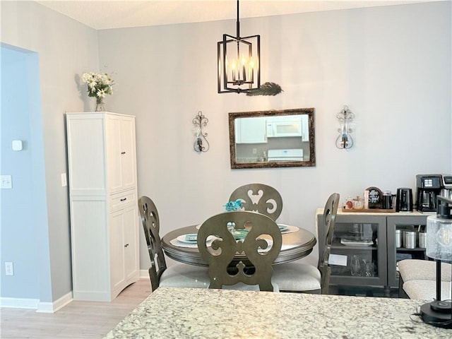 4172 Howell Park Rd, Duluth, GA 30096 - dining area featuring light wood-style flooring and a chandelier