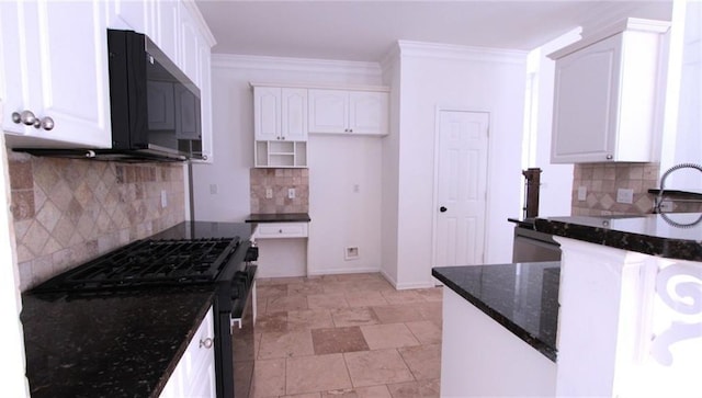 kitchen featuring dark stone counters, ornamental molding, black gas range, and white cabinetry