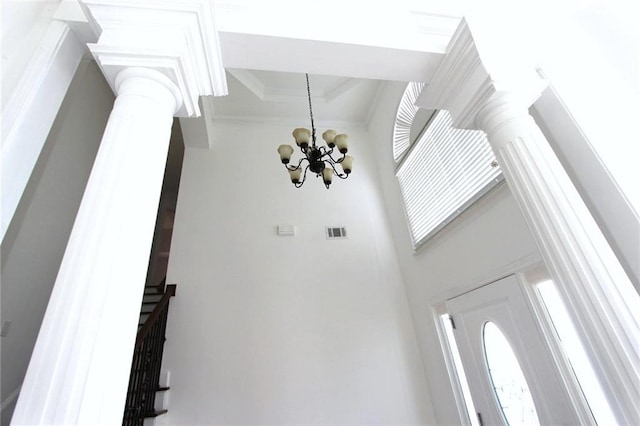 interior space with stairs, ornamental molding, decorative columns, and an inviting chandelier