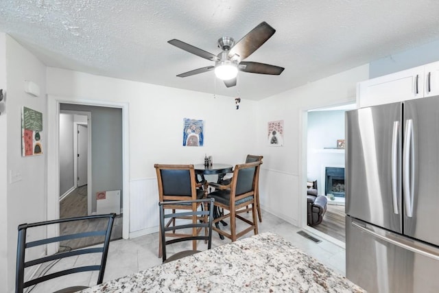 1279 Skyhaven Rd SE, Atlanta, GA 30316 - dining area with a ceiling fan, a fireplace, and a textured ceiling