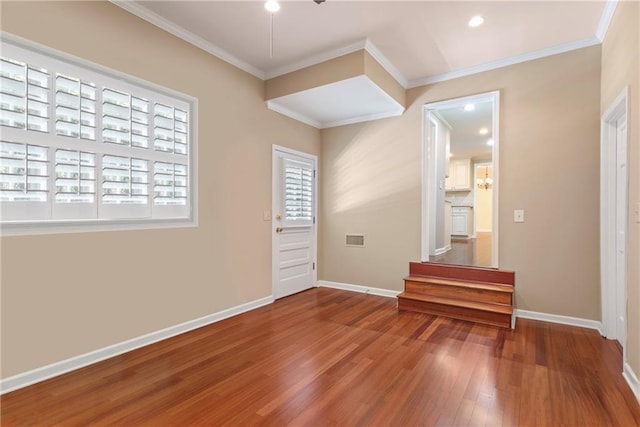 empty room featuring wood-type flooring and crown molding