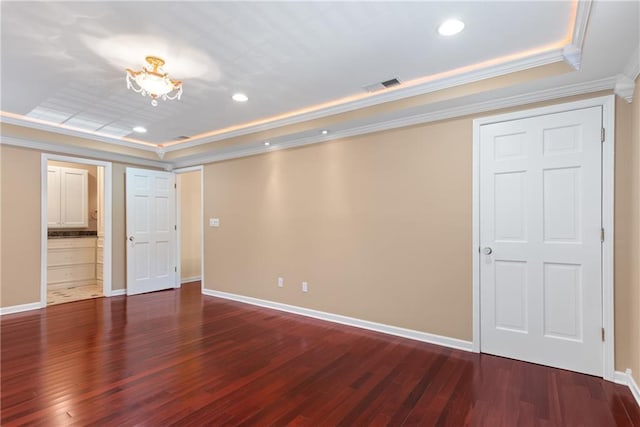 unfurnished bedroom with dark wood-type flooring, ornamental molding, and a raised ceiling