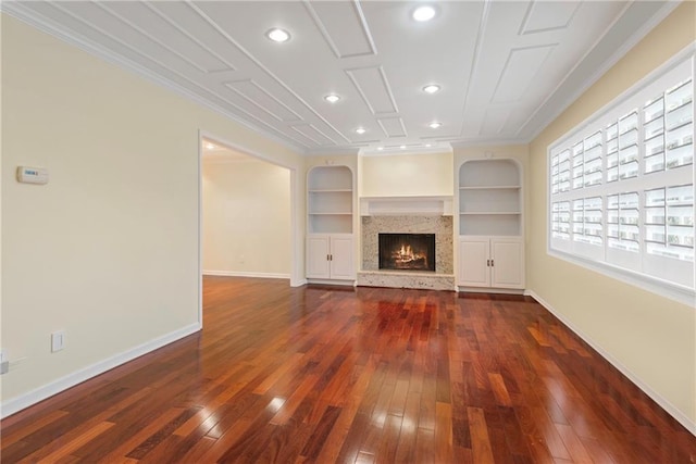 unfurnished living room featuring ornamental molding, dark hardwood / wood-style floors, and built in shelves