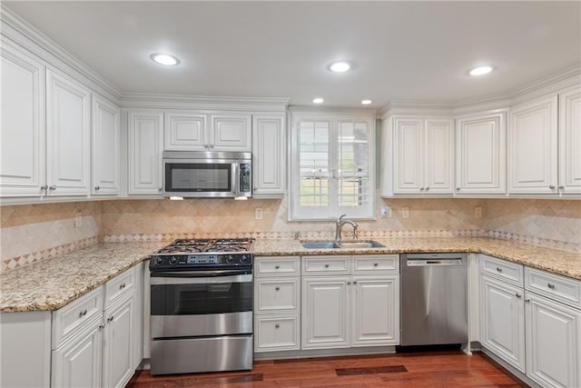 kitchen with sink, stainless steel appliances, dark hardwood / wood-style floors, light stone counters, and white cabinets