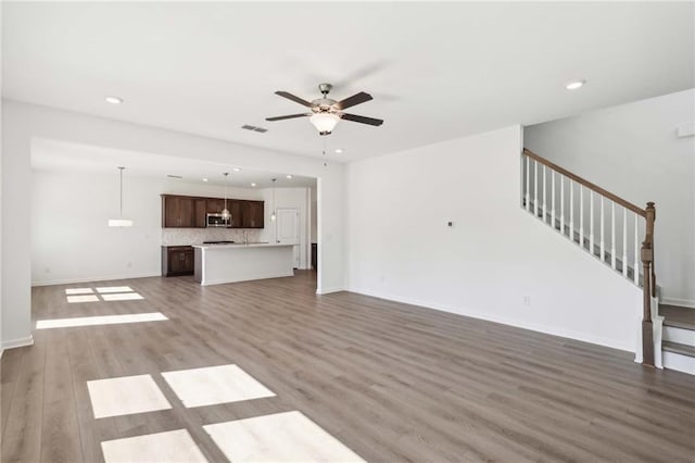 unfurnished living room with ceiling fan and wood-type flooring