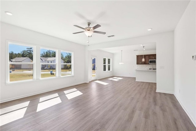 unfurnished living room featuring light hardwood / wood-style floors and ceiling fan