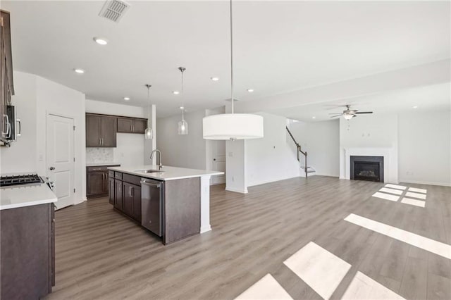 kitchen featuring ceiling fan, sink, stainless steel dishwasher, an island with sink, and pendant lighting