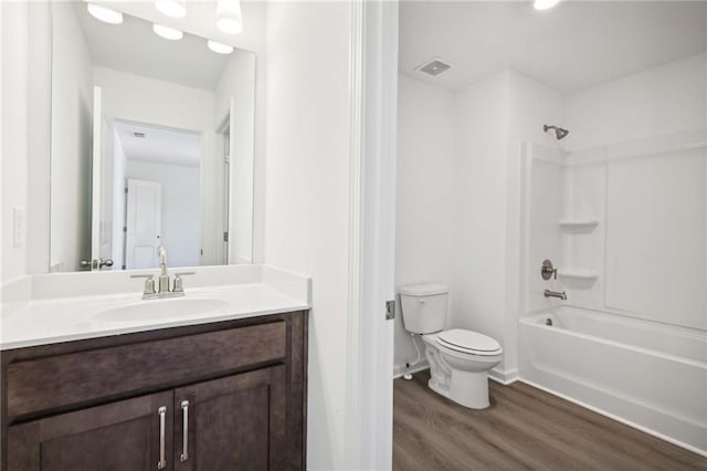 full bathroom featuring toilet, vanity, hardwood / wood-style flooring, and bathing tub / shower combination