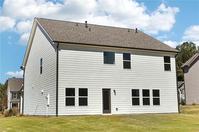 rear view of house featuring a lawn