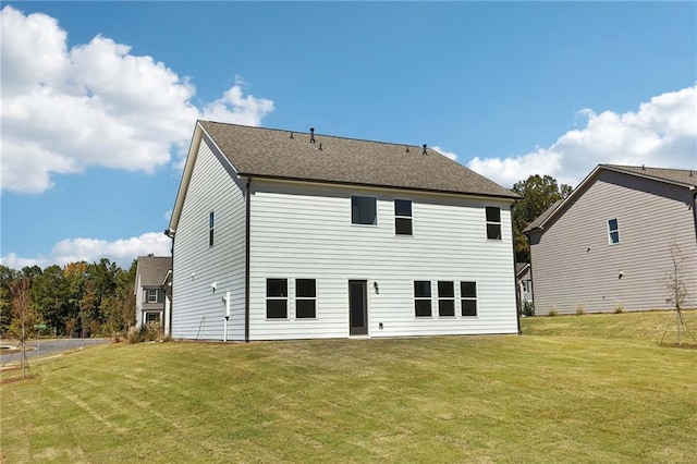 rear view of house featuring a lawn