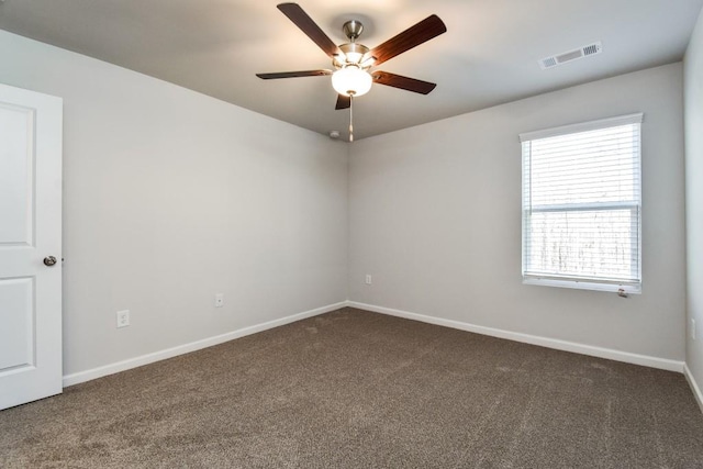 spare room featuring dark colored carpet and ceiling fan