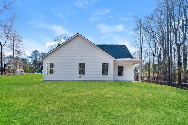 back of property featuring a yard