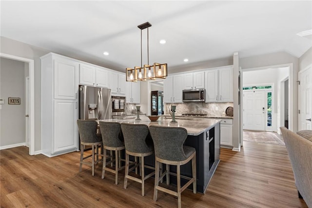 7537 Brookstone Cir, Flowery Branch, GA 30542 - kitchen with appliances with stainless steel finishes, wood finished floors, white cabinets, tasteful backsplash, and recessed lighting