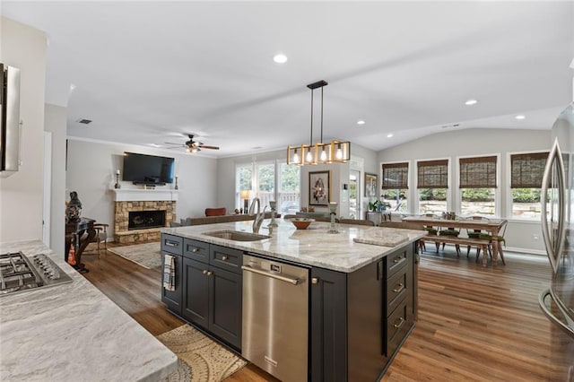 7537 Brookstone Cir, Flowery Branch, GA 30542 - kitchen featuring appliances with stainless steel finishes, a stone fireplace, ceiling fan, dark wood-style flooring, and open floor plan