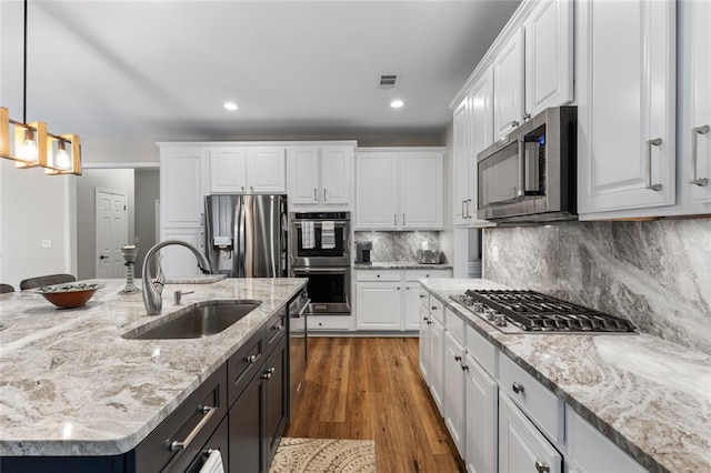 7537 Brookstone Cir, Flowery Branch, GA 30542 - kitchen featuring stainless steel appliances, white cabinets, wood finished floors, hanging light fixtures, and recessed lighting