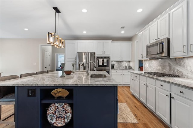 7537 Brookstone Cir, Flowery Branch, GA 30542 - kitchen with stainless steel appliances, open shelves, a kitchen breakfast bar, a kitchen island with sink, and white cabinetry