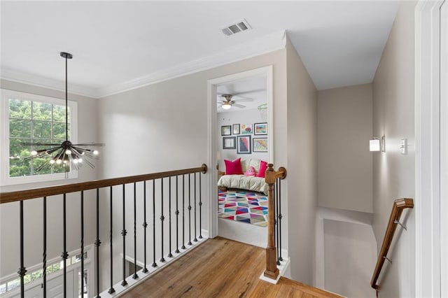7537 Brookstone Cir, Flowery Branch, GA 30542 - corridor featuring wood finished floors, an upstairs landing, a chandelier, and ornamental molding