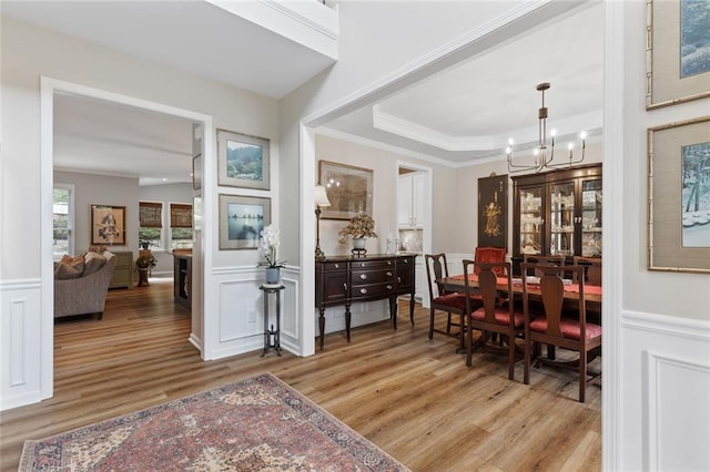 7537 Brookstone Cir, Flowery Branch, GA 30542 - dining space with crown molding, light wood-type flooring, a decorative wall, a chandelier, and wainscoting