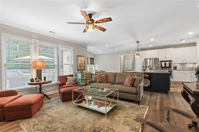 7537 Brookstone Cir, Flowery Branch, GA 30542 - living room featuring light wood finished floors, ceiling fan, crown molding, and recessed lighting