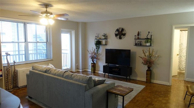 living room with ceiling fan and dark parquet flooring