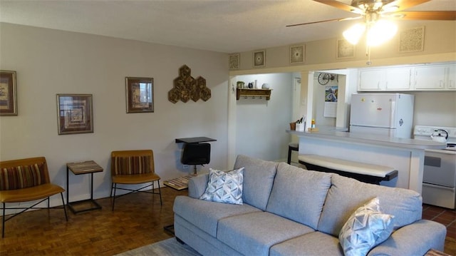 living room featuring dark parquet floors and ceiling fan