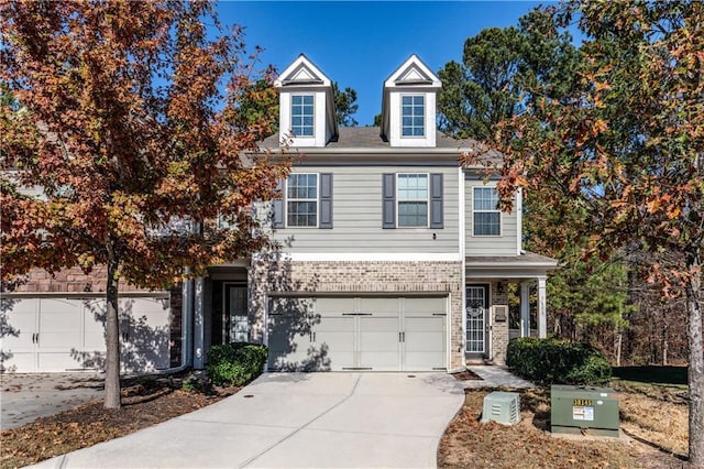 view of front of property featuring concrete driveway, brick siding, and an attached garage