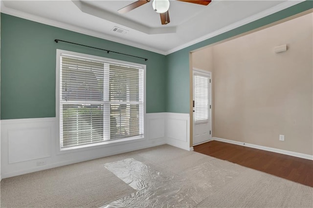 spare room featuring hardwood / wood-style floors, a raised ceiling, ceiling fan, and ornamental molding